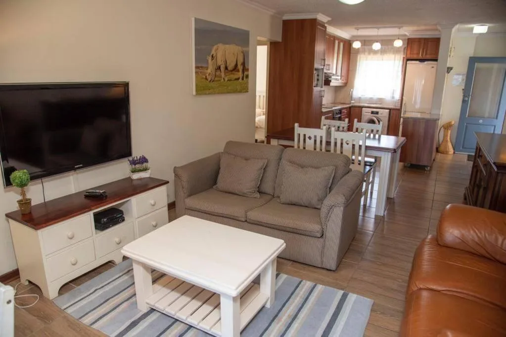 Open-plan lounge with gray sofa, TV, and coffee table in contemporary apartment