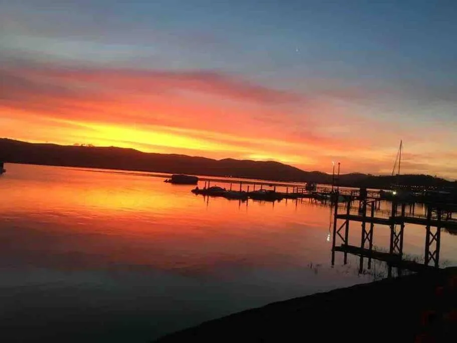 Stunning sunset over Knysna Lagoon with boats and jetty silhouettes