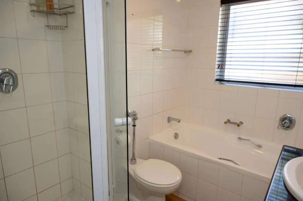 Clean bathroom with shower stall, bathtub, toilet, and window