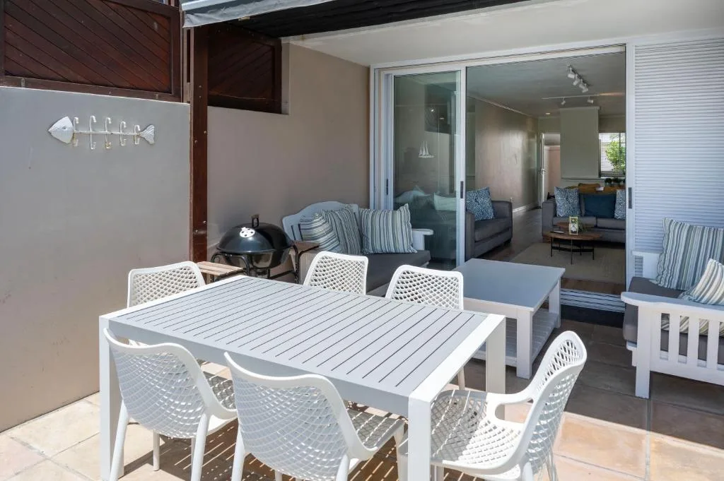 Outdoor patio with dining table, lounge seating, and interior view