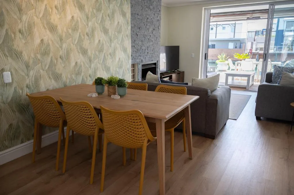 Modern dining table with mustard chairs overlooking open lounge area