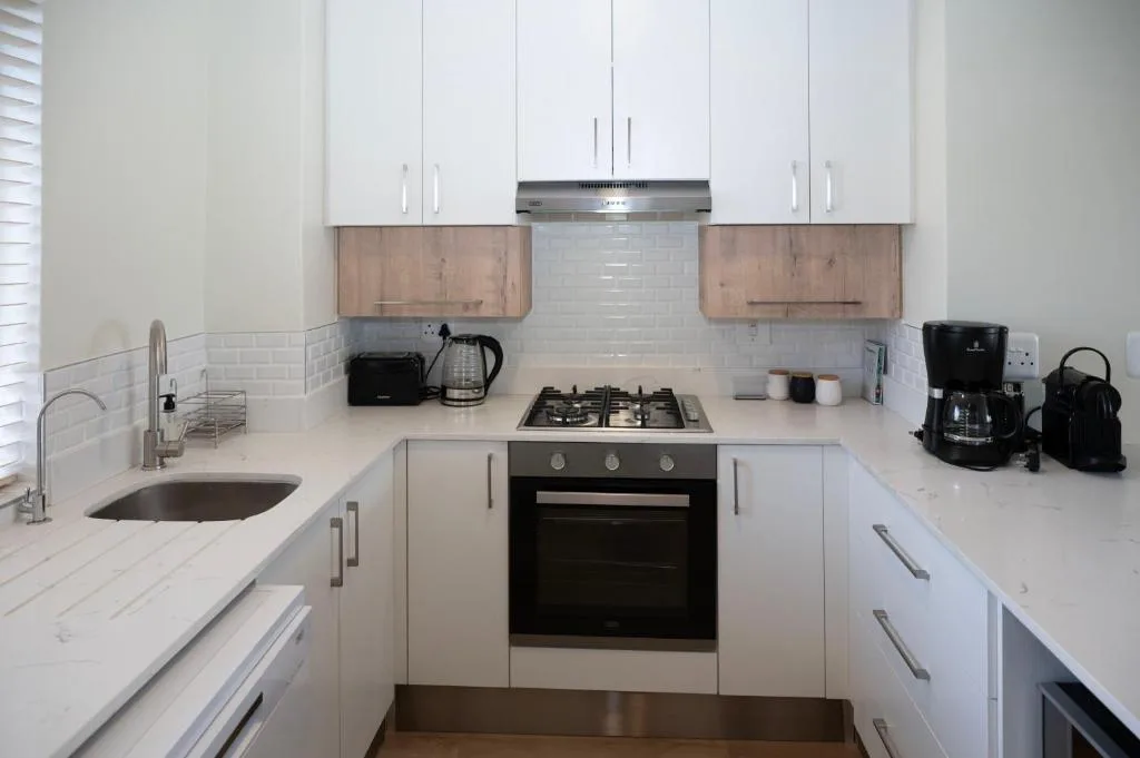 Modern white kitchen with gas stove, subway tile backsplash, and stainless appliances