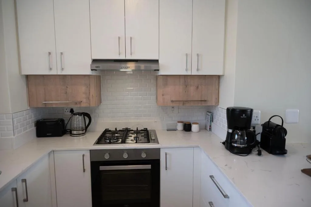 Modern kitchen with white cabinetry, gas cooktop, and stainless steel appliances