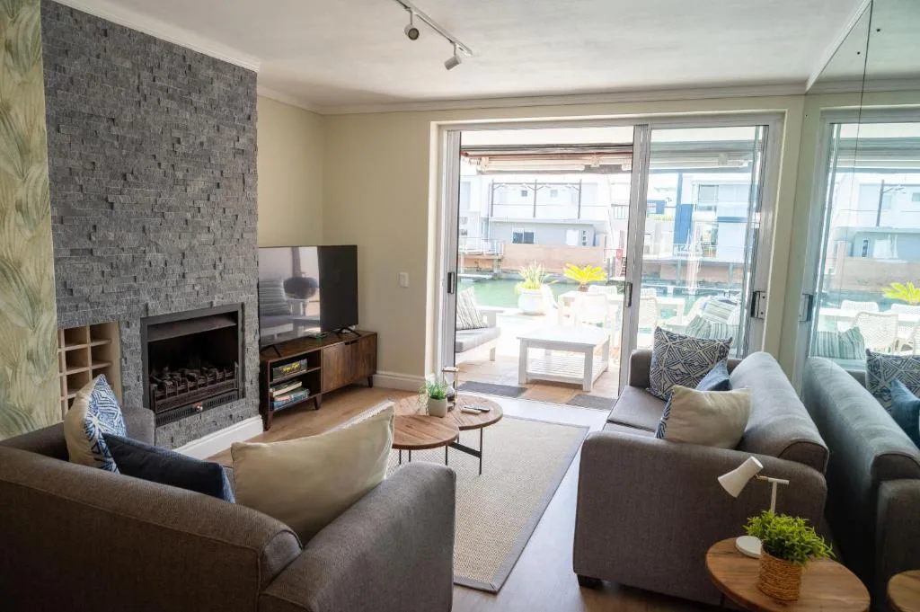 Spacious lounge with fireplace, comfortable seating, and glass doors opening to deck