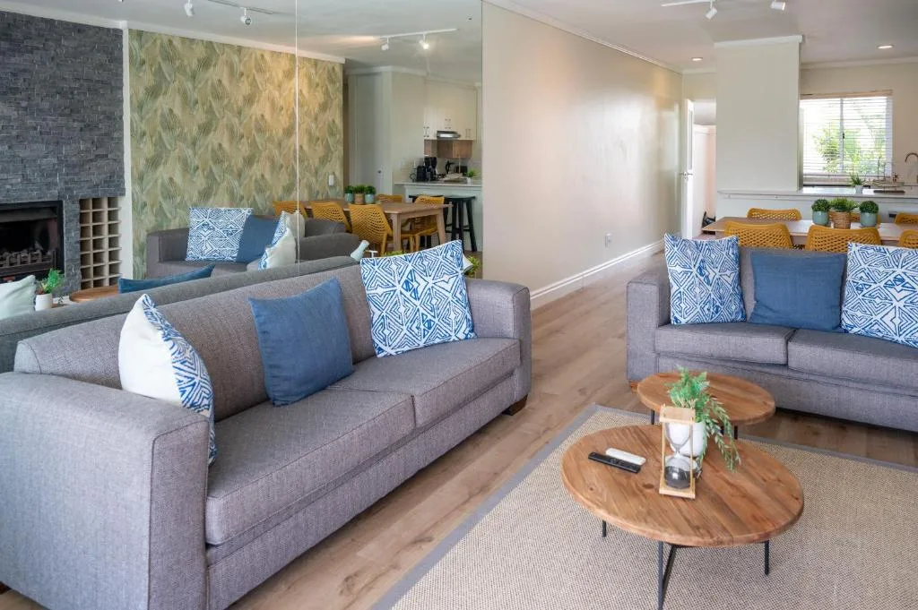 Modern living room with gray sofas, blue patterned cushions, wooden coffee table
