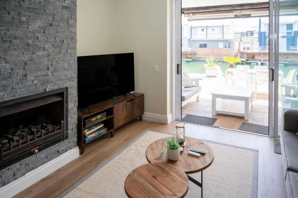Modern living room with fireplace, TV, and sliding door to deck