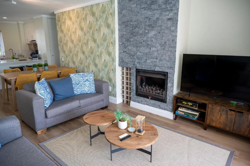 Modern lounge with gray sofa, fireplace, TV, and wood coffee table