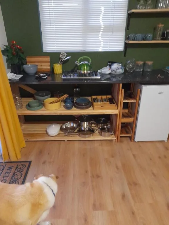 Modern kitchen with black countertop, wooden shelving, gas stove, and organized utensils