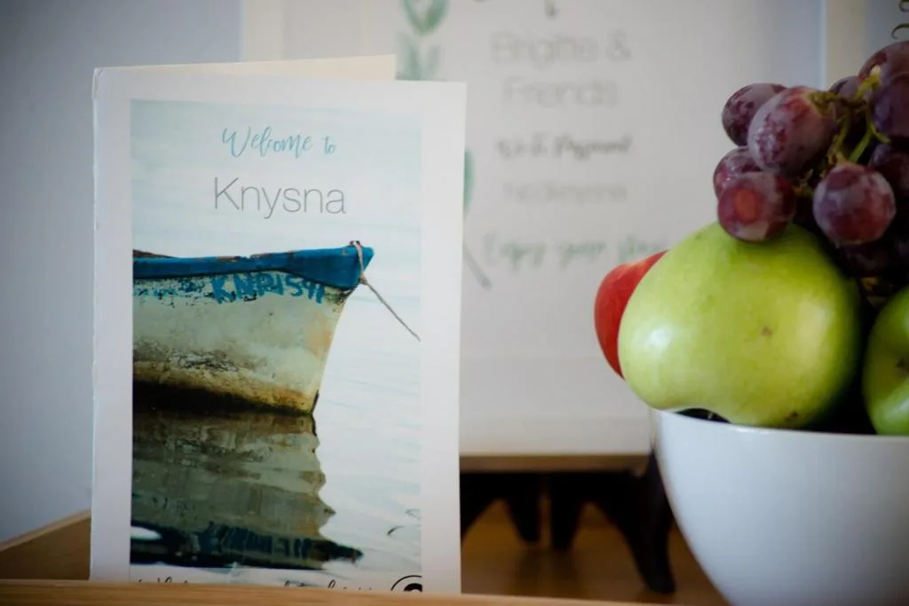 Welcome card for Knysna property with boat image and fresh fruit bowl