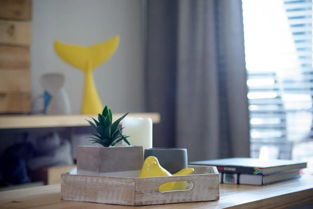 Decorative wooden tray with succulent plant and yellow accents on desk