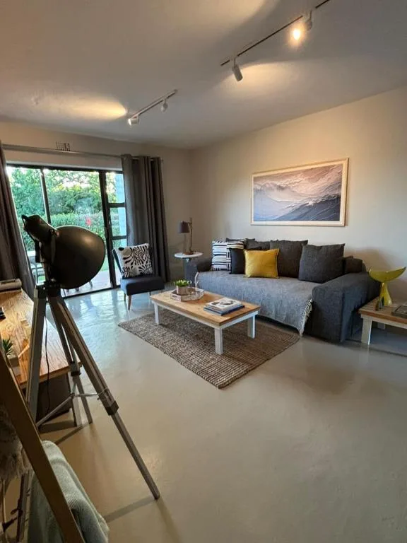 Modern living room with blue sofa, coffee table, and garden views