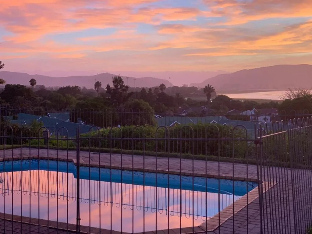 Swimming pool at sunset with mountain and lagoon views beyond