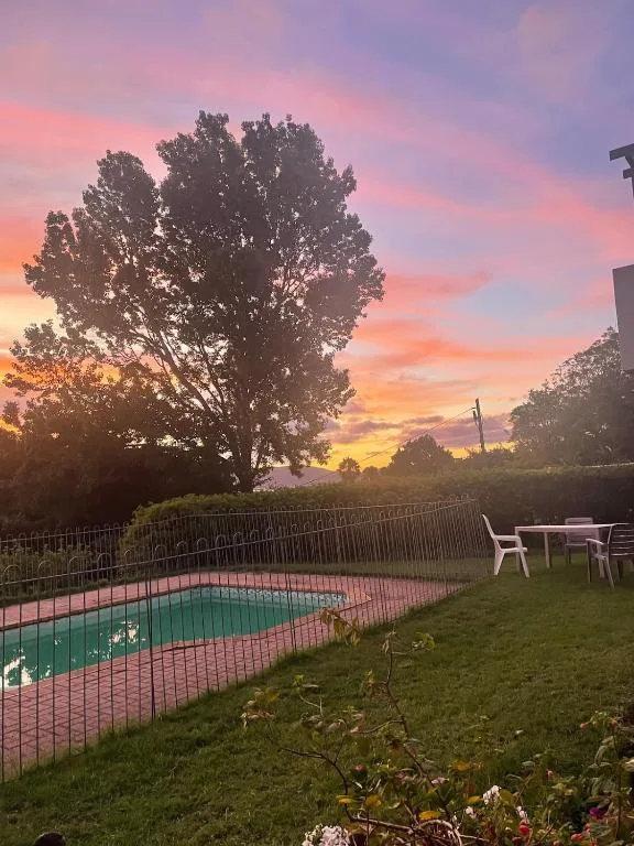 Swimming pool at sunset with vibrant pink and orange sky reflecting above
