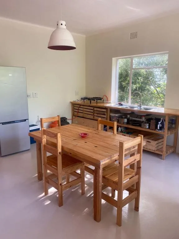 Modern kitchen with wooden dining table, stainless refrigerator, and garden views