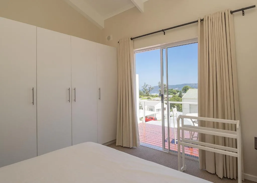 Spacious bedroom with built-in wardrobes and sliding doors opening to mountain views