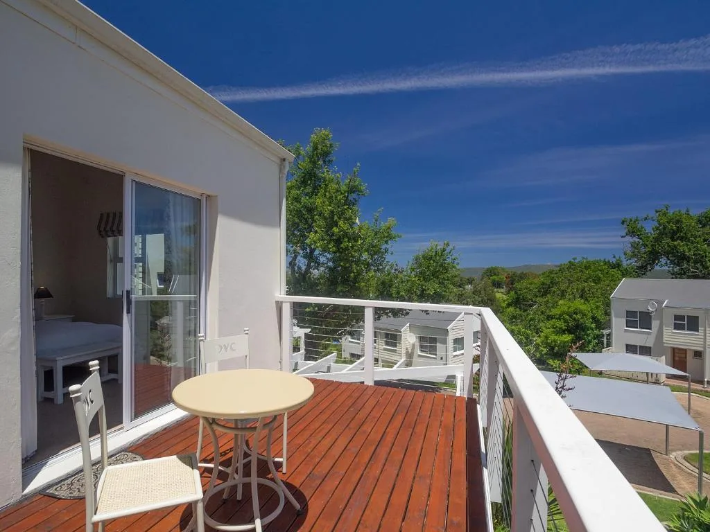 Wooden deck with outdoor table and chairs overlooking green hills