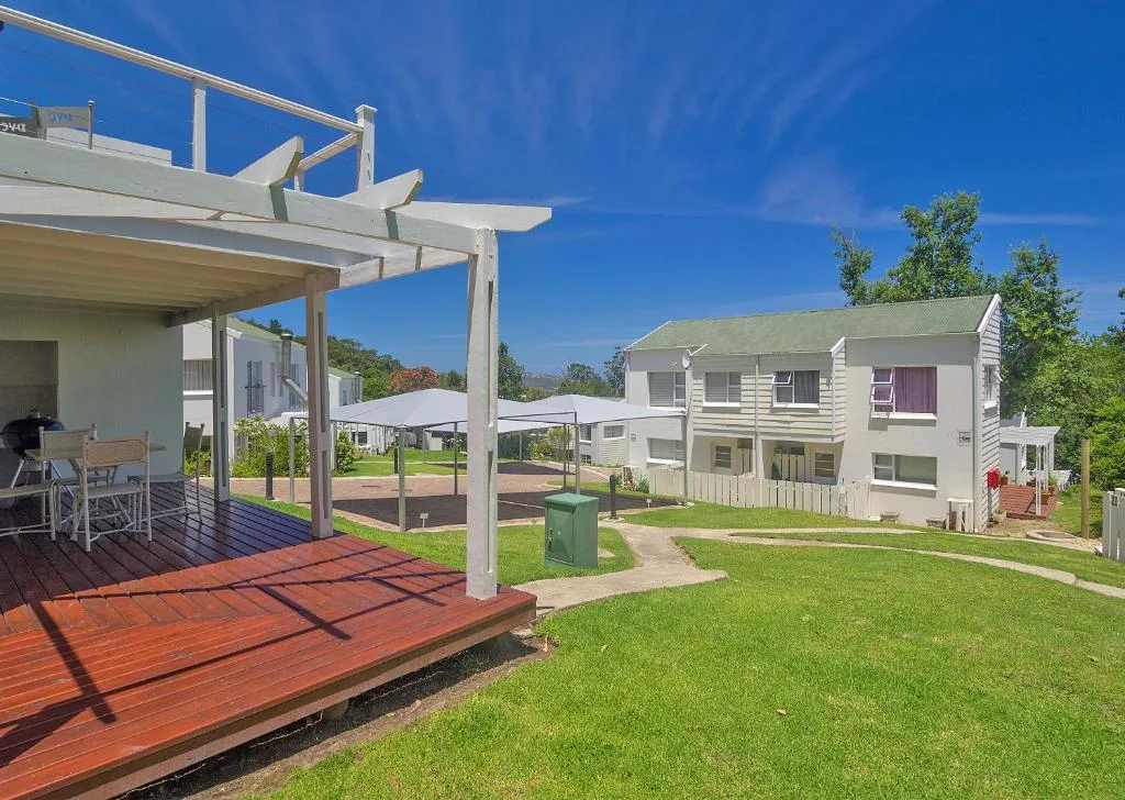 Wooden deck with pergola overlooking manicured garden and neighbouring properties