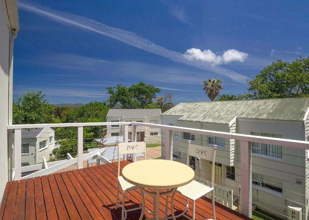 Wooden deck with round table and chairs overlooking resort grounds
