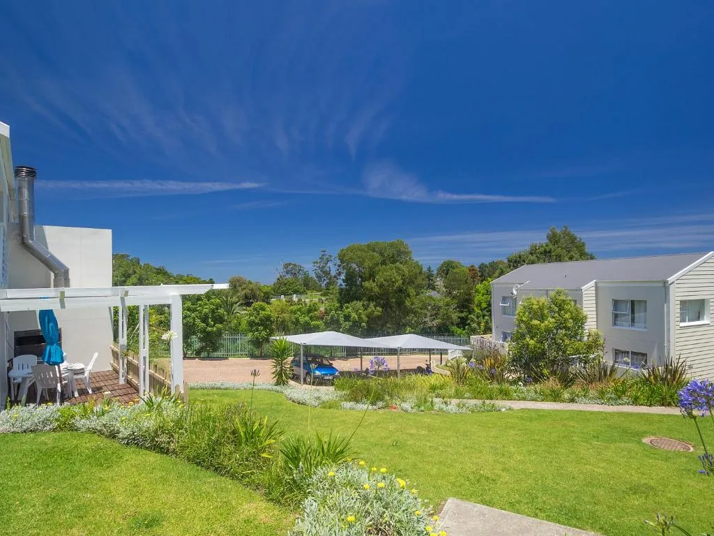 Modern white holiday home with manicured gardens and pool area