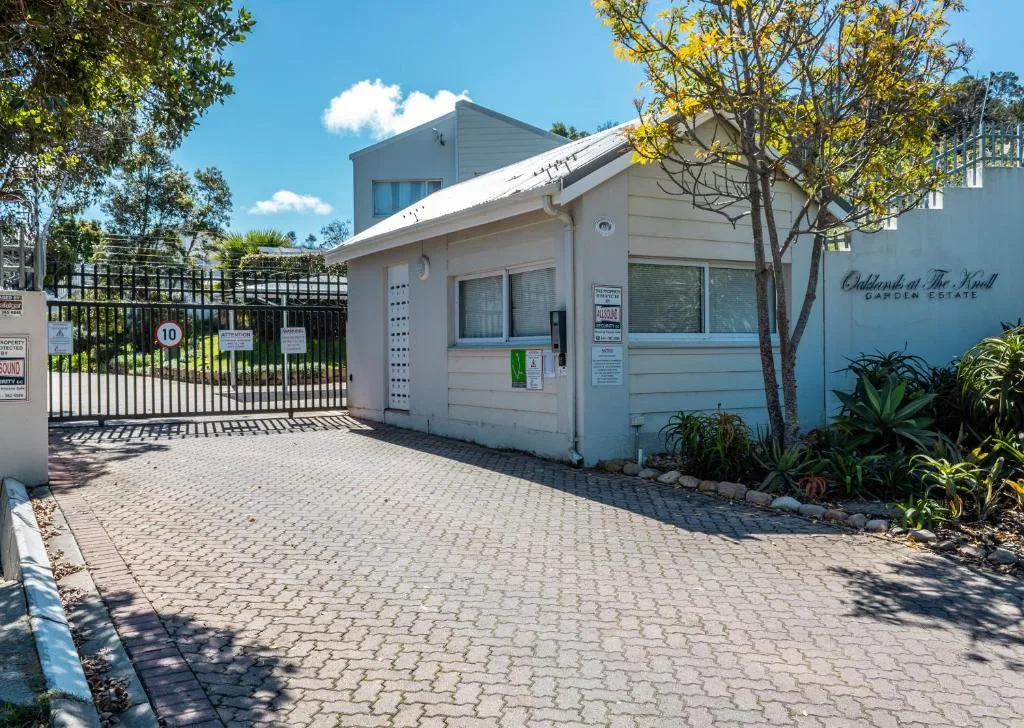 Modern white holiday home with gated entrance and manicured gardens