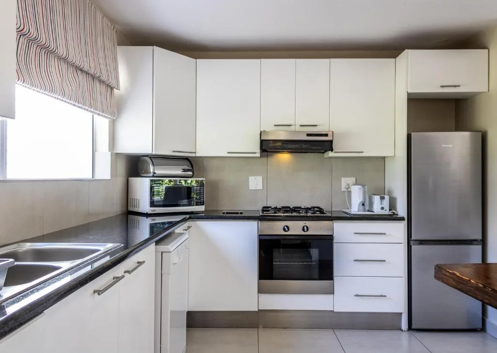 Modern kitchen with white cabinetry, gas stove, and stainless steel appliances