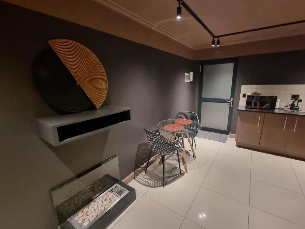 Modern lounge with dining table, contemporary wall art, and open-plan kitchen area