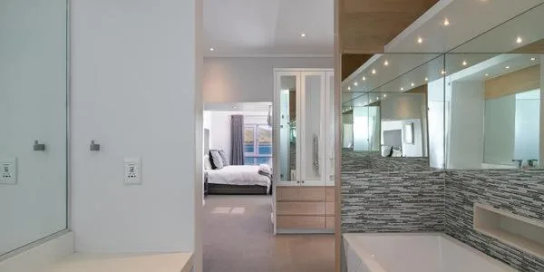 Modern bathroom with striped tile feature wall and large mirror