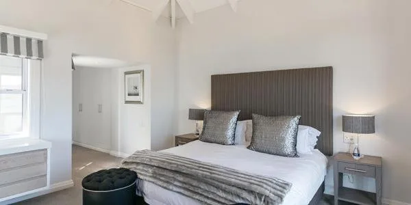 Modern bedroom with queen bed, grey headboard, and bedside tables with lamps