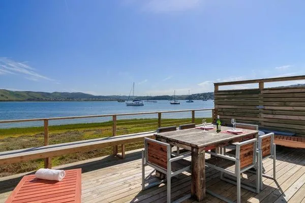 Wooden deck with dining table overlooking sailboats and Knysna lagoon