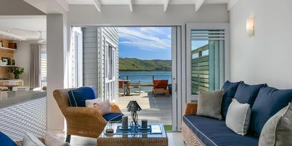 Coastal lounge with ocean view through open glass doors to deck