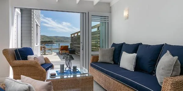 Bright lounge with wicker furniture overlooking Knysna waterfront and mountains