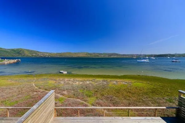 Turquoise bay waters with moored sailboats and green hillsides beyond