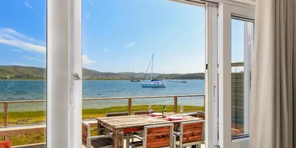 Scenic waterfront view of Knysna lagoon with sailboats and green hills