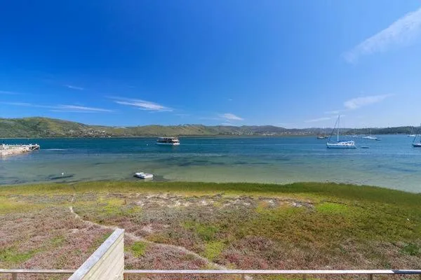 Turquoise lagoon waters with moored sailboats and green hillsides beyond