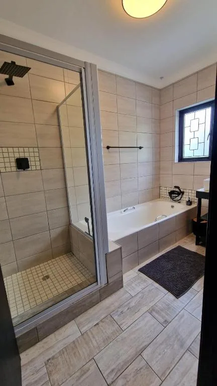 Modern bathroom with walk-in shower, soaking tub, and tiled flooring