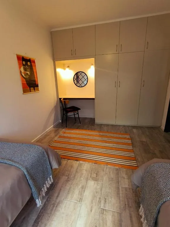 Spacious bedroom with twin beds, built-in wardrobes, striped runner rug