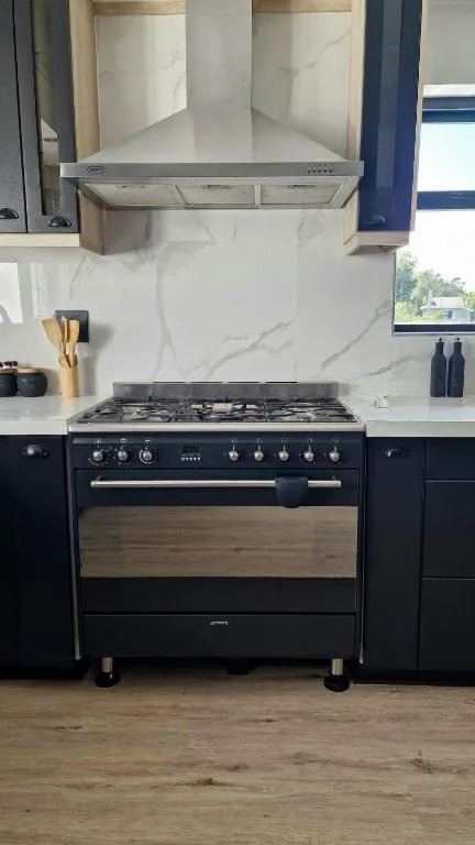 Modern kitchen with black range cooker and marble splashback