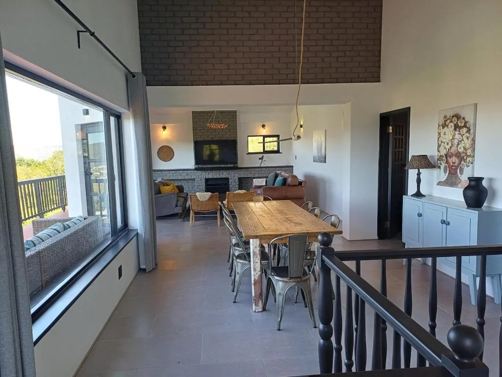 Open-plan lounge and dining area with wooden table and fireplace