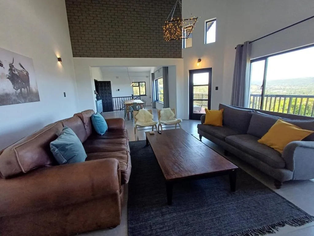Spacious lounge with leather sofas and panoramic garden views