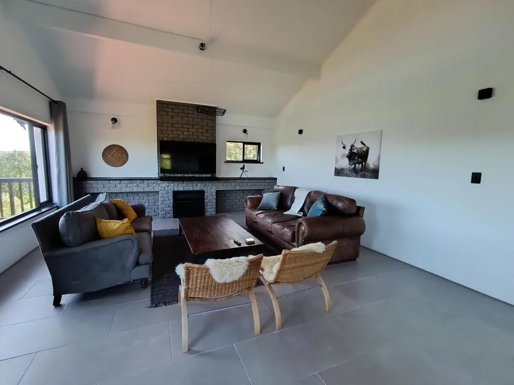 Spacious lounge with leather sofas, fireplace, and large windows