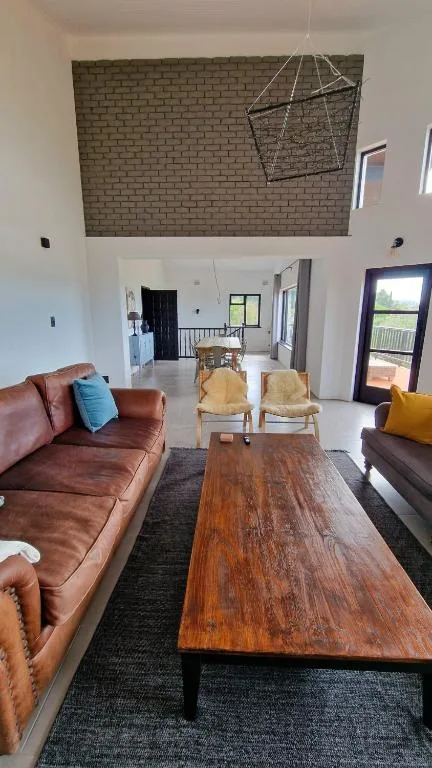 Open-plan lounge with cognac leather sofa and wooden coffee table