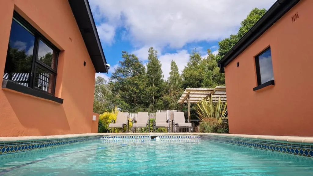 Inviting turquoise swimming pool surrounded by terracotta buildings and garden views