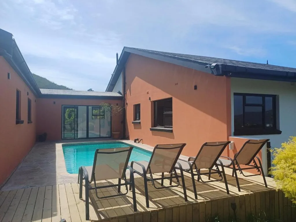 Swimming pool with loungers and modern orange villa architecture