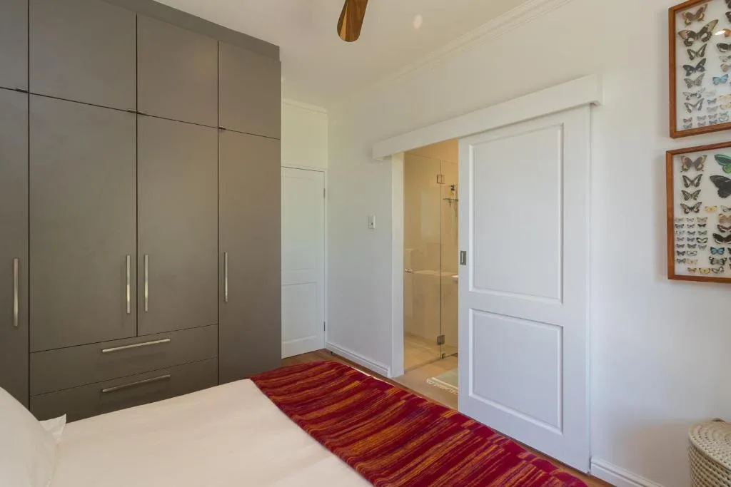Bedroom with modern wardrobe, ensuite bathroom, butterfly artwork decor