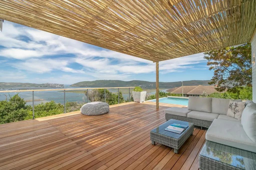 Wooden deck with lounge seating overlooking lagoon and mountains