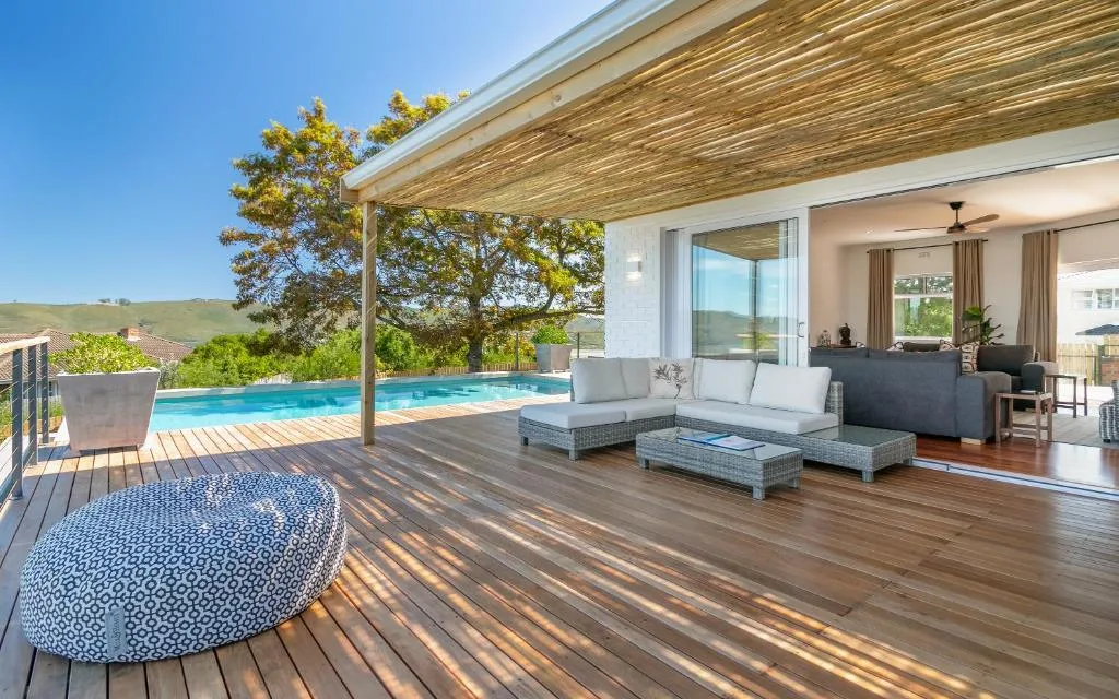 Spacious wooden deck with lounge seating, pool, and valley views