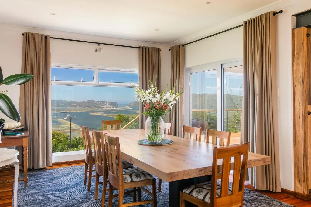 Spacious dining room with lagoon views through large windows and glass doors