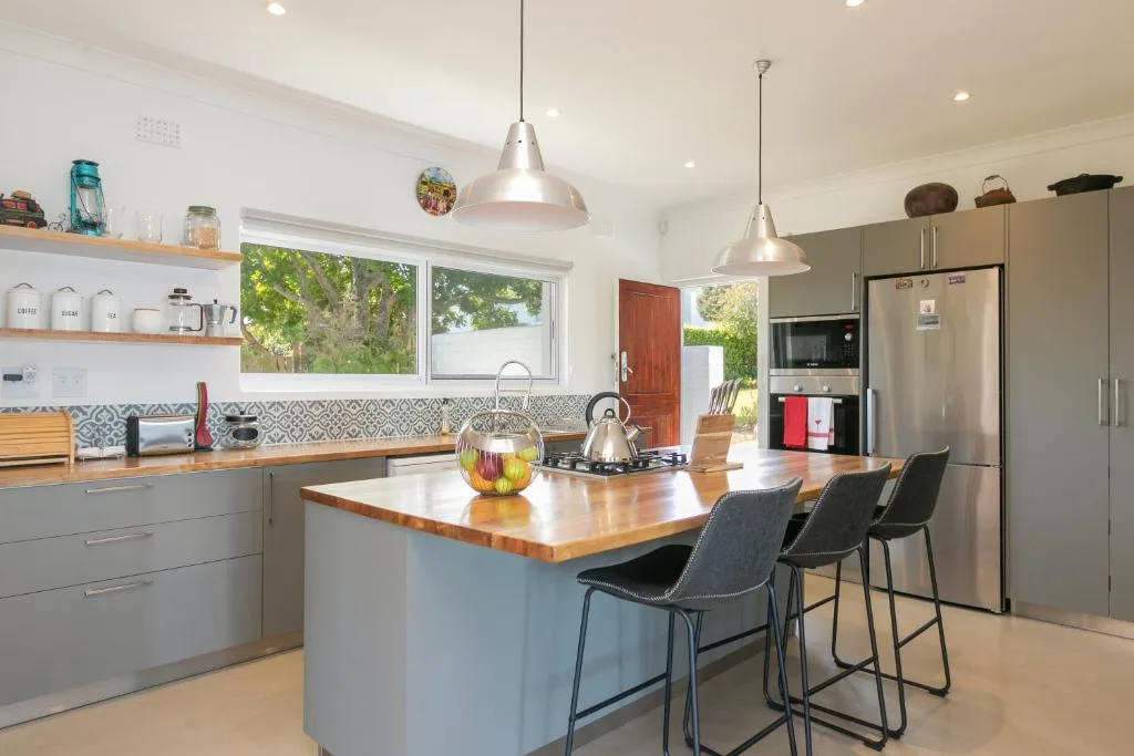 Modern kitchen with island bench, stainless steel appliances, and garden views