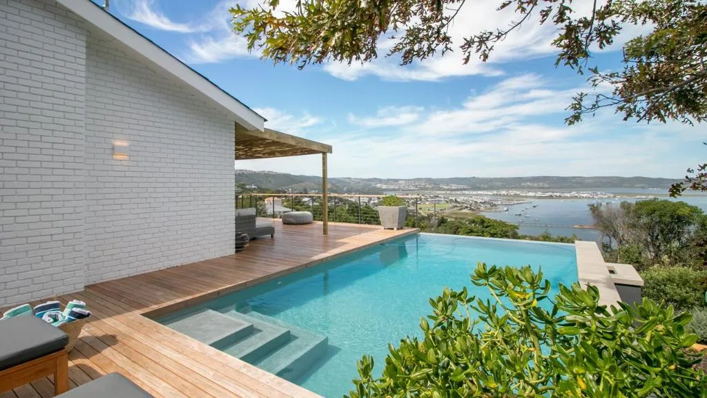 Infinity pool overlooking Knysna lagoon with wooden deck and coastal views