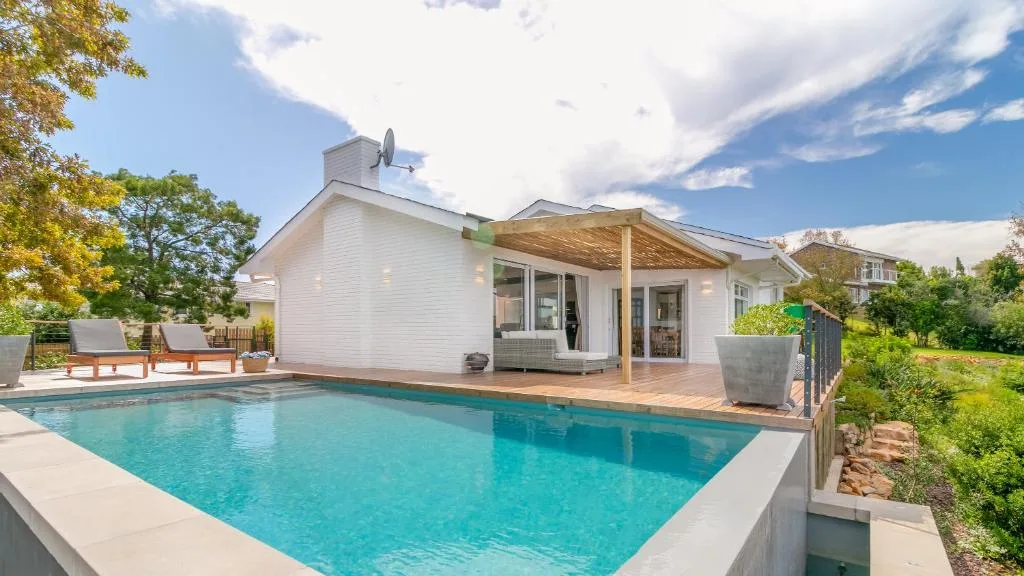 Modern home with sparkling turquoise swimming pool and wooden deck